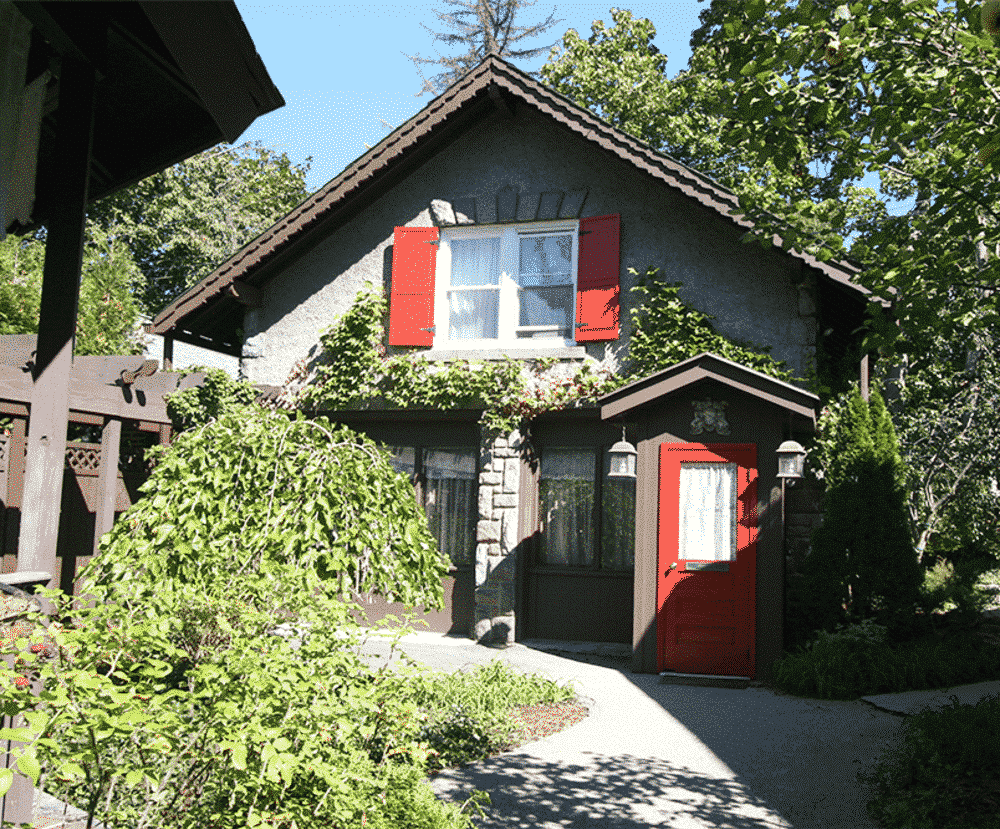A small house with red shutters on the windows