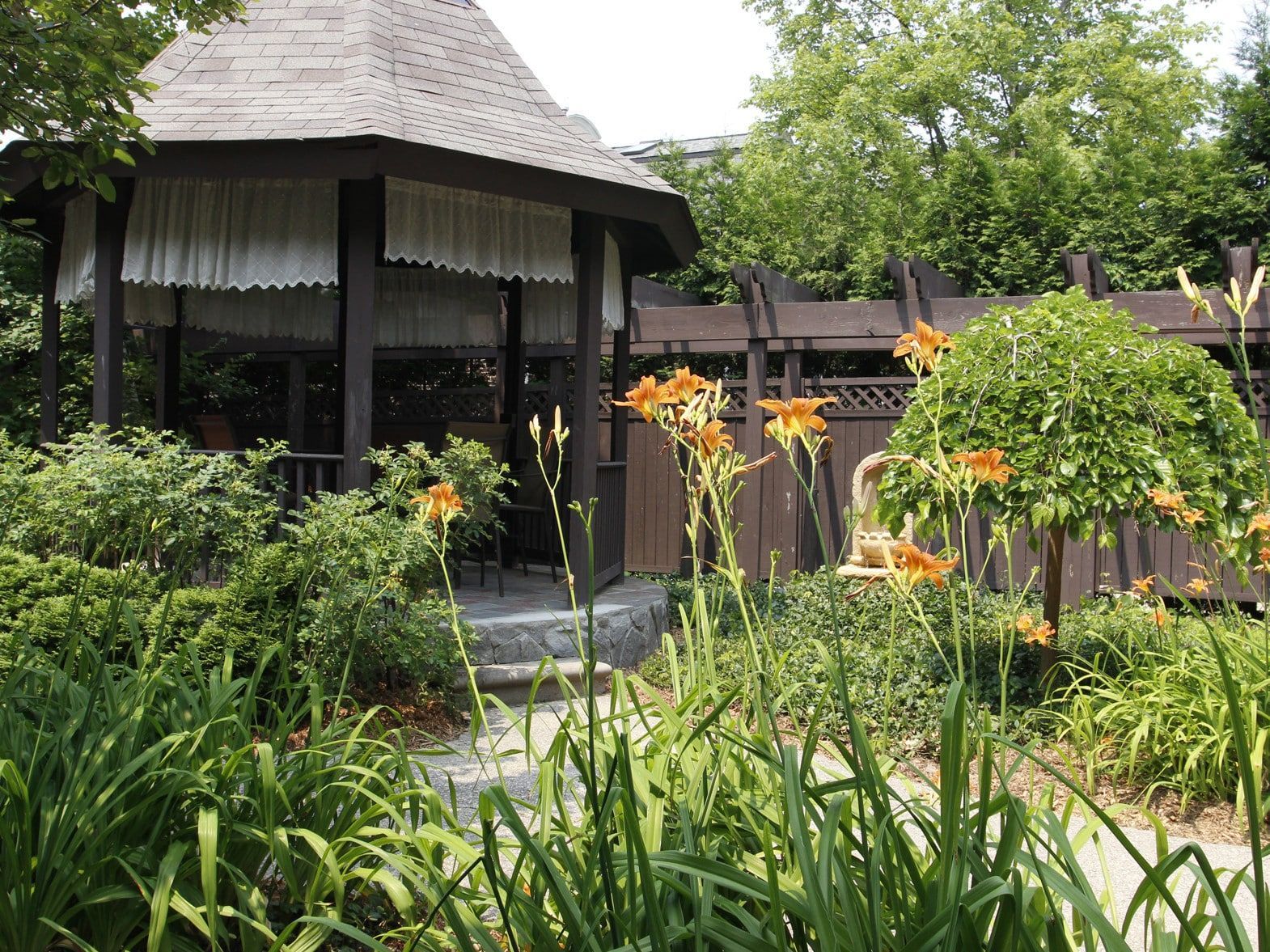 A gazebo in the middle of a garden with flowers
