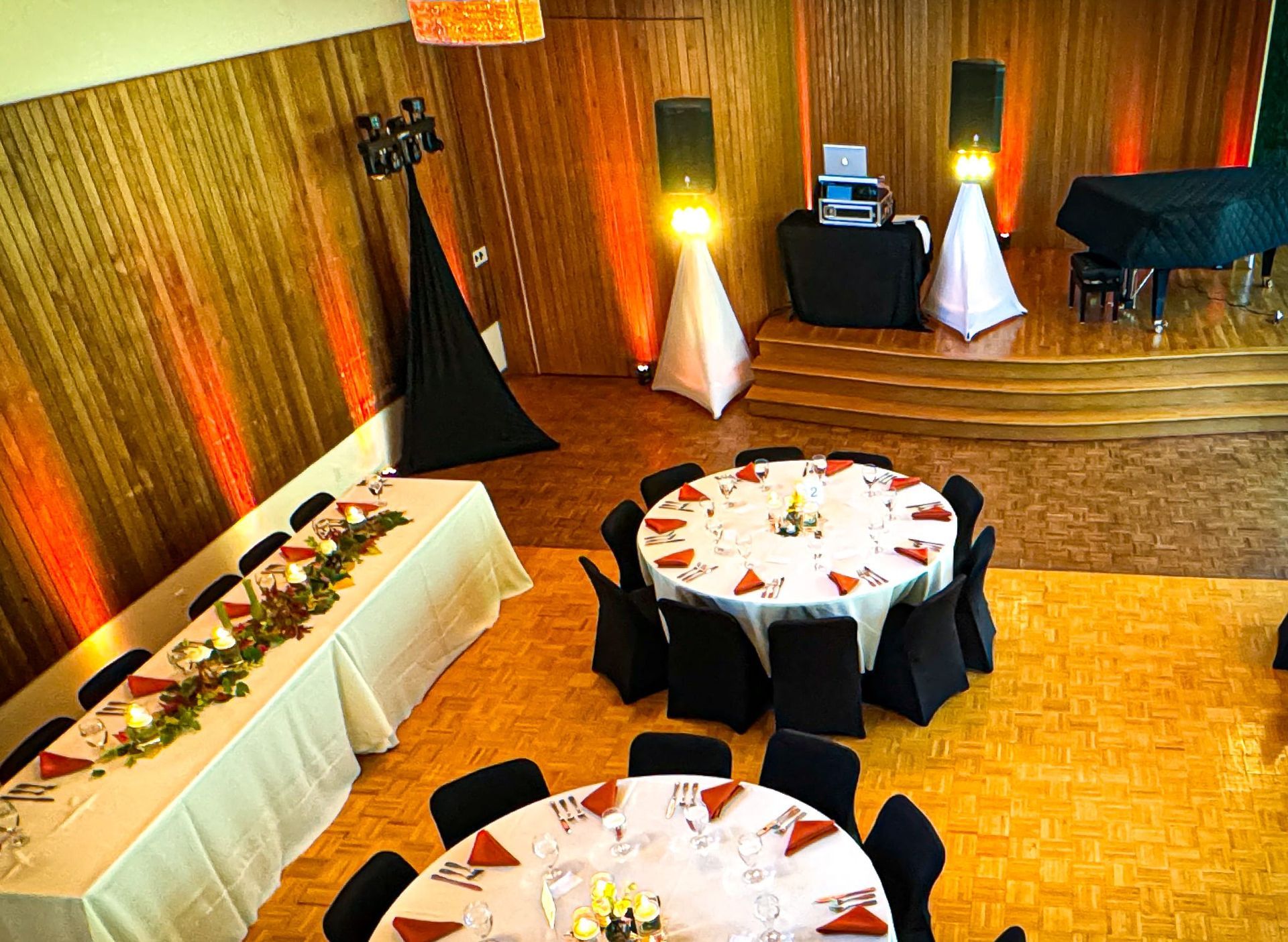 A large room with tables and chairs set up for a wedding reception.