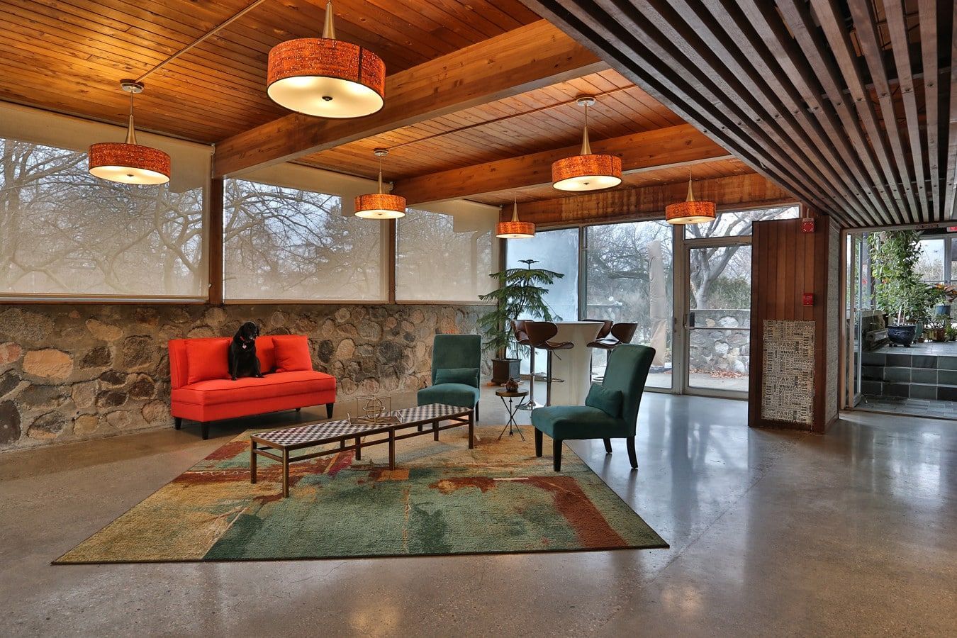 A living room with a red couch and green chairs