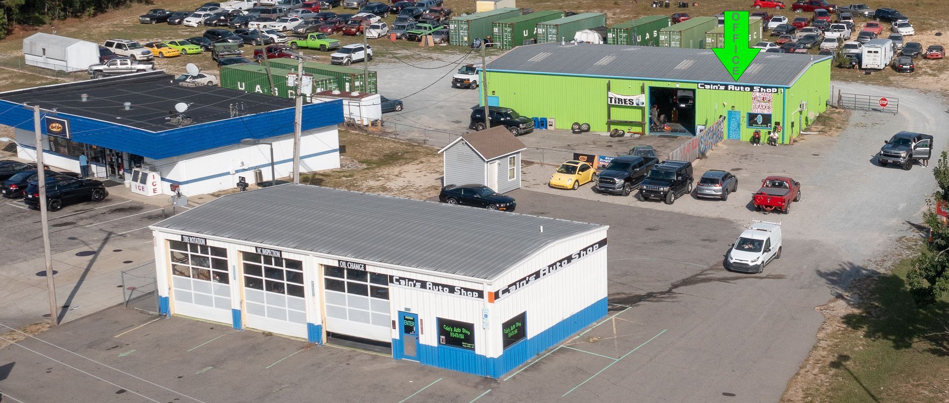 A bright green auto shop with a white truck and van parked outside. | Cain's Auto Shop