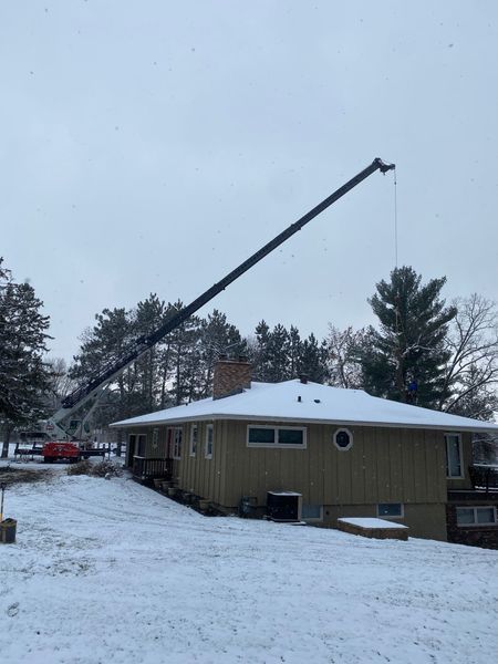 A house with a crane in front of it in the snow
