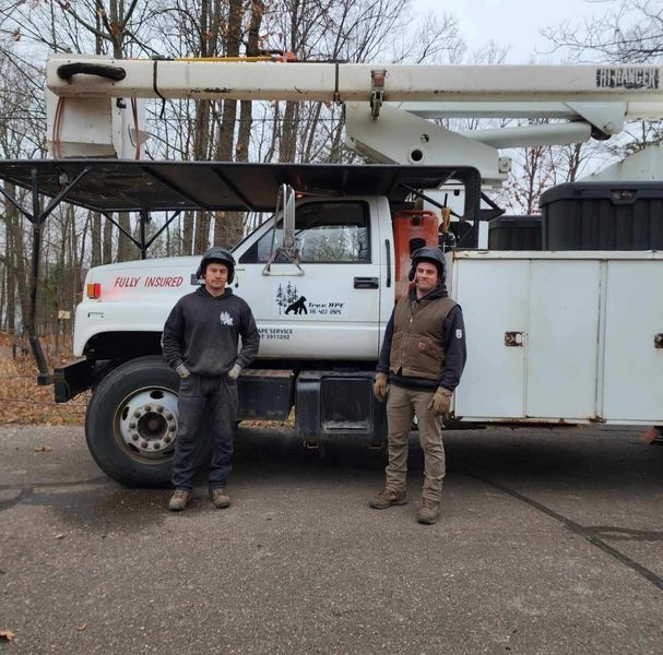 Two men standing in front of a truck that says utility