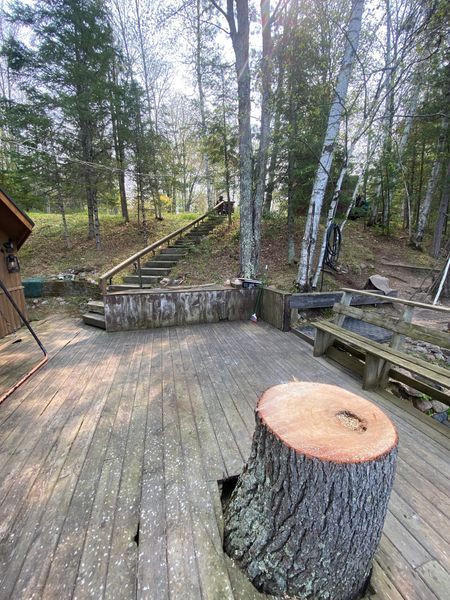 A wooden deck with a tree stump in the middle of it.