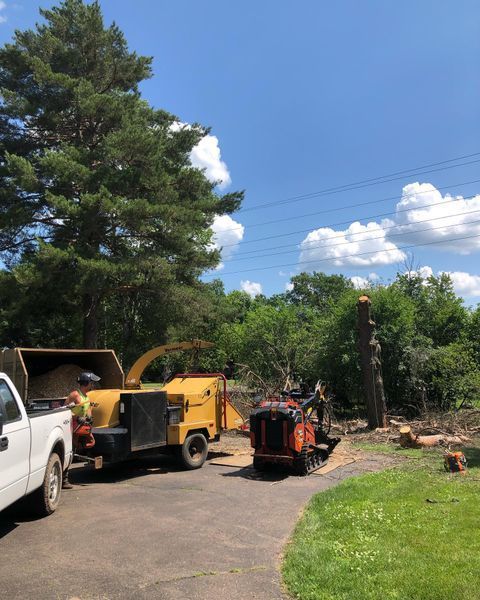 A white truck is parked next to a tree chipper.