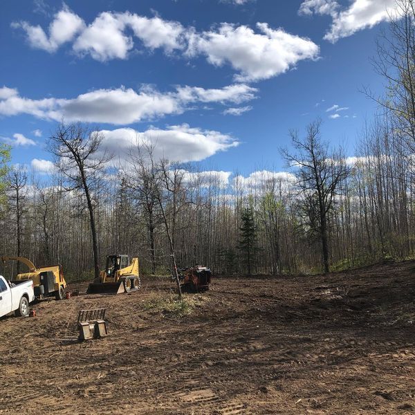 A white truck is parked in the middle of a dirt field.