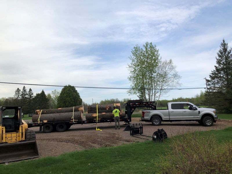 A truck is being towed by a bulldozer and a crane.