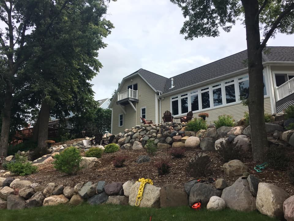 A large house is sitting on top of a rocky hill.