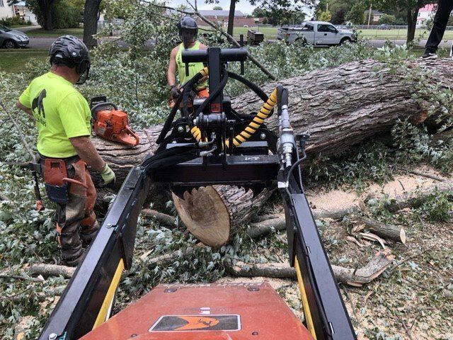 A man is using a machine to remove a tree stump.