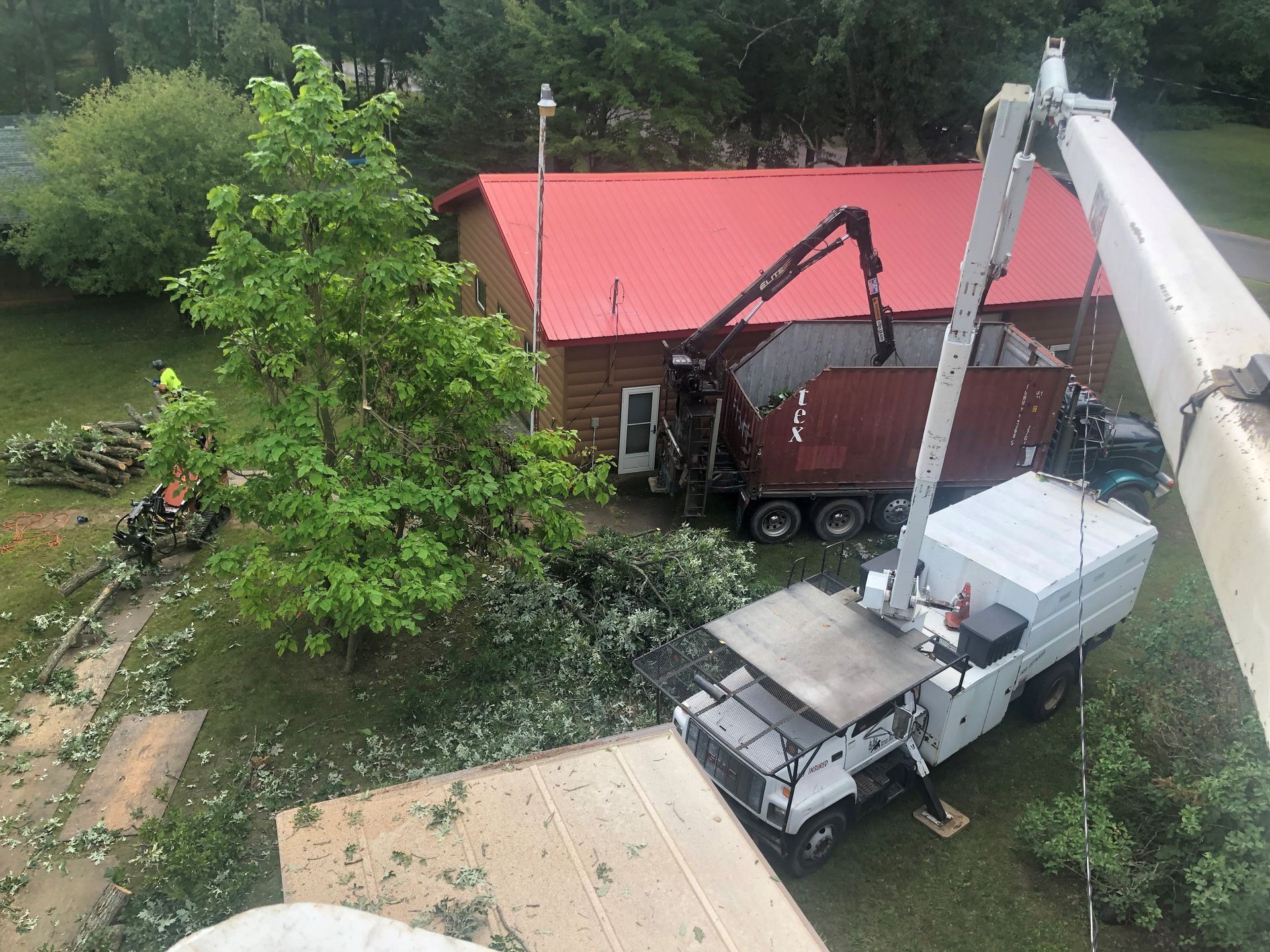 A white truck is parked in front of a house with a red roof.