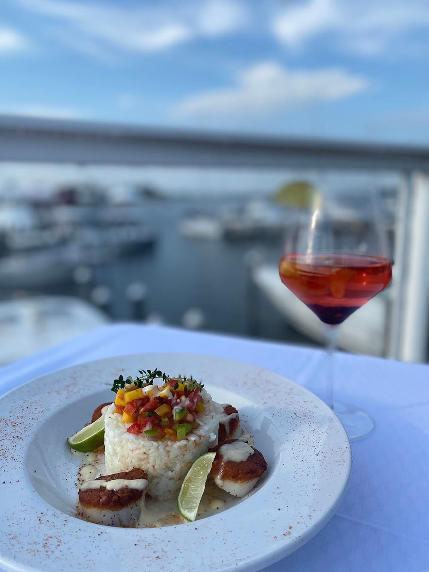 A plate of food and a glass of wine on a table.