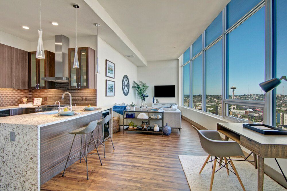A kitchen and living room in a large apartment with lots of windows at Tower12 Apartments.