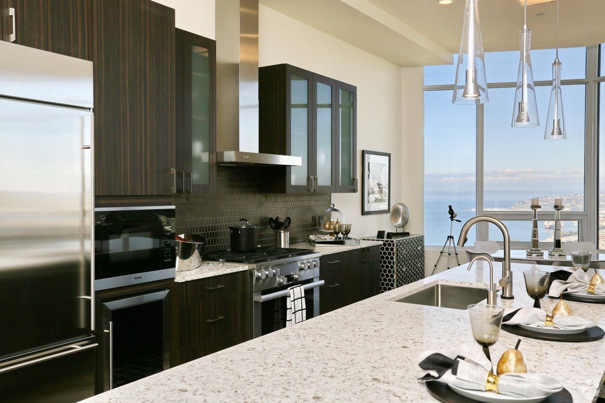 A kitchen with stainless steel appliances and granite counter tops at Tower12 Apartments.