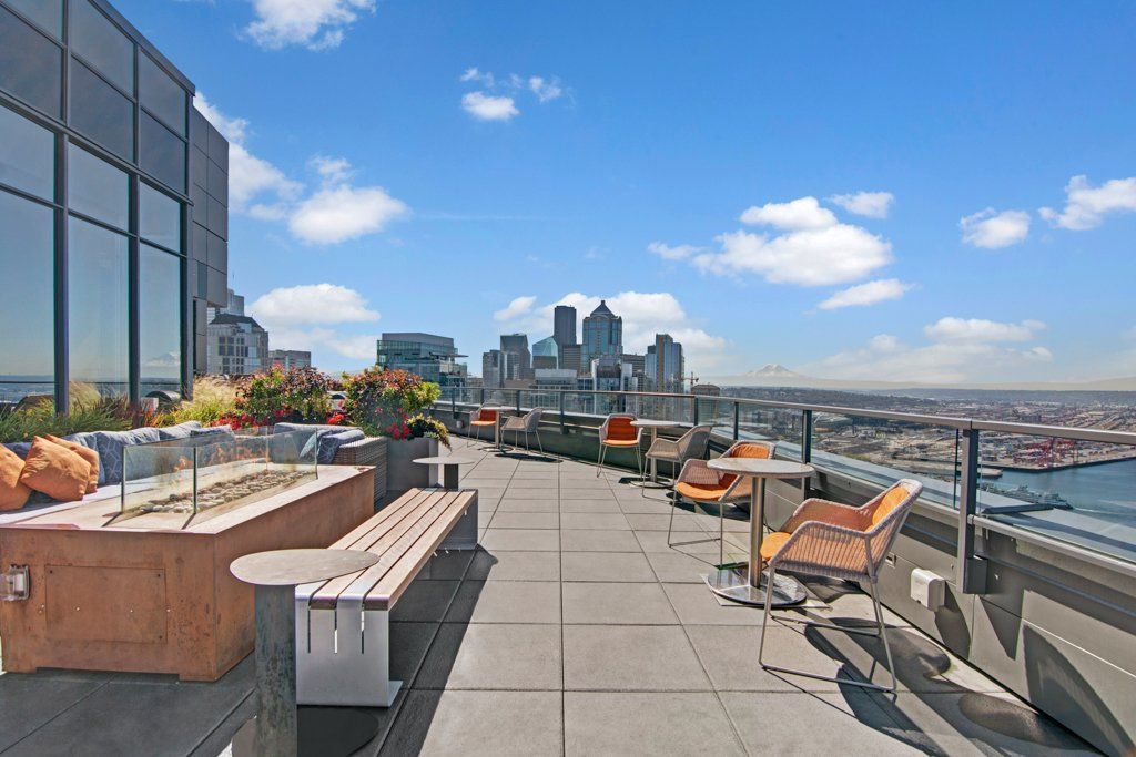 A rooftop deck with a fire pit and a view of the city at Tower12 Apartments.