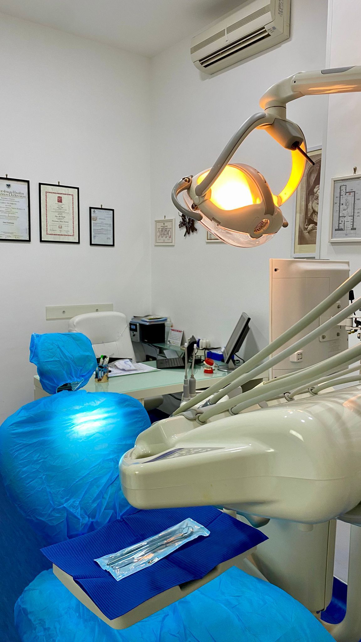 Sala visita odontoiatrica con poltrona per il paziente, lampada a soffitto e attrezzatura.
