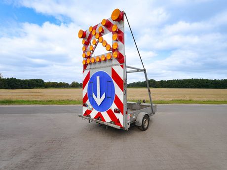 Absperr Anhänger steht auf einer gepflasterten Fläche.