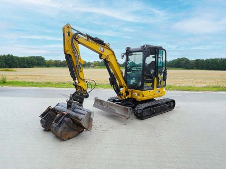 Gelb-schwarzer CAT-301-5-Minibagger auf einer gepflasterten Fläche.