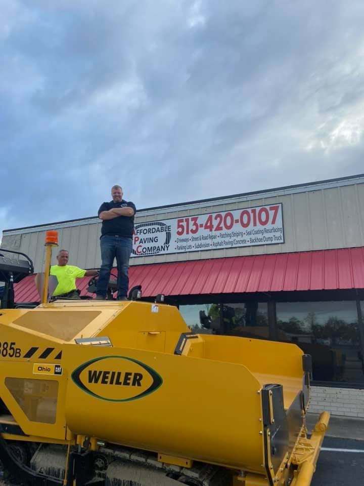 A Man Standing On Top Of A Yellow Machine | Middletown, OH | Affordable Paving Company