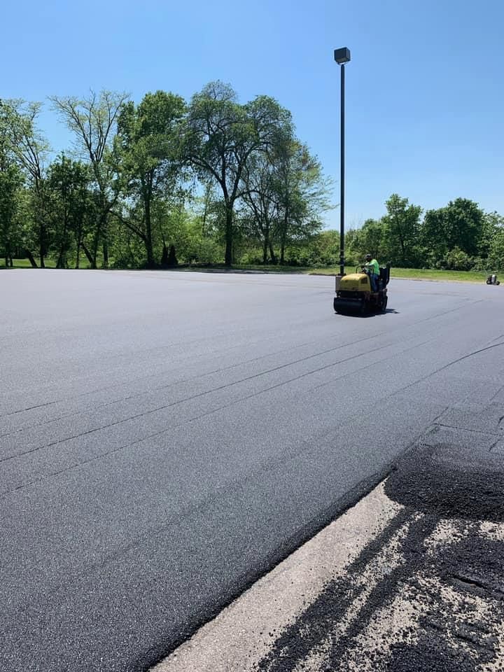 A Man Is Using A Roller To Spread Asphalt | Middletown, OH | Affordable Paving Company