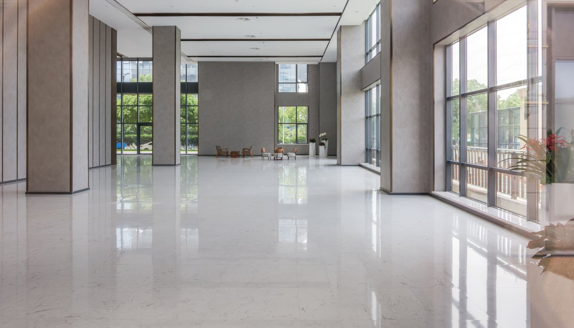A large empty lobby with a shiny marble floor and lots of windows.