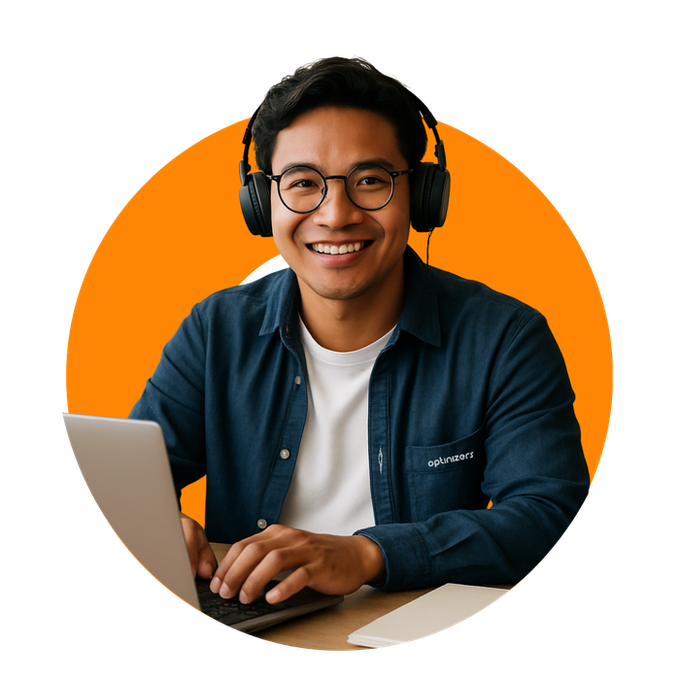 Man with glasses and headphones smiling while working on a laptop. Orange background.