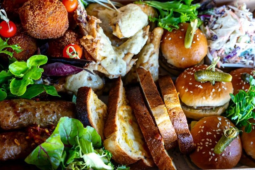 A Close Up of a Plate of Food With Bread, Hamburgers, and Vegetables — Darwin Catering Company in Brinkin, NT