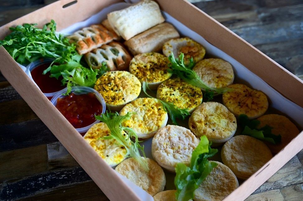 A Box Filled With a Variety of Food on a Wooden Table — Darwin Catering Company in Brinkin, NT