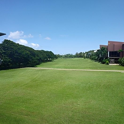 A Lush Green Field With a Building in the Background — Darwin Catering Company in Brinkin, NT