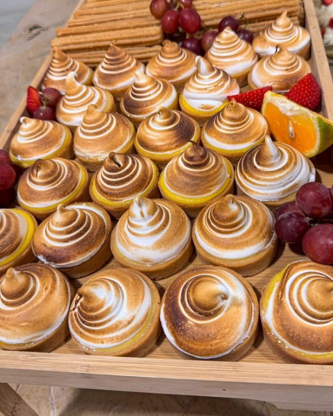 A Wooden Tray Filled With Cupcakes and Fruit on a Table — Darwin Catering Company in Brinkin, NT