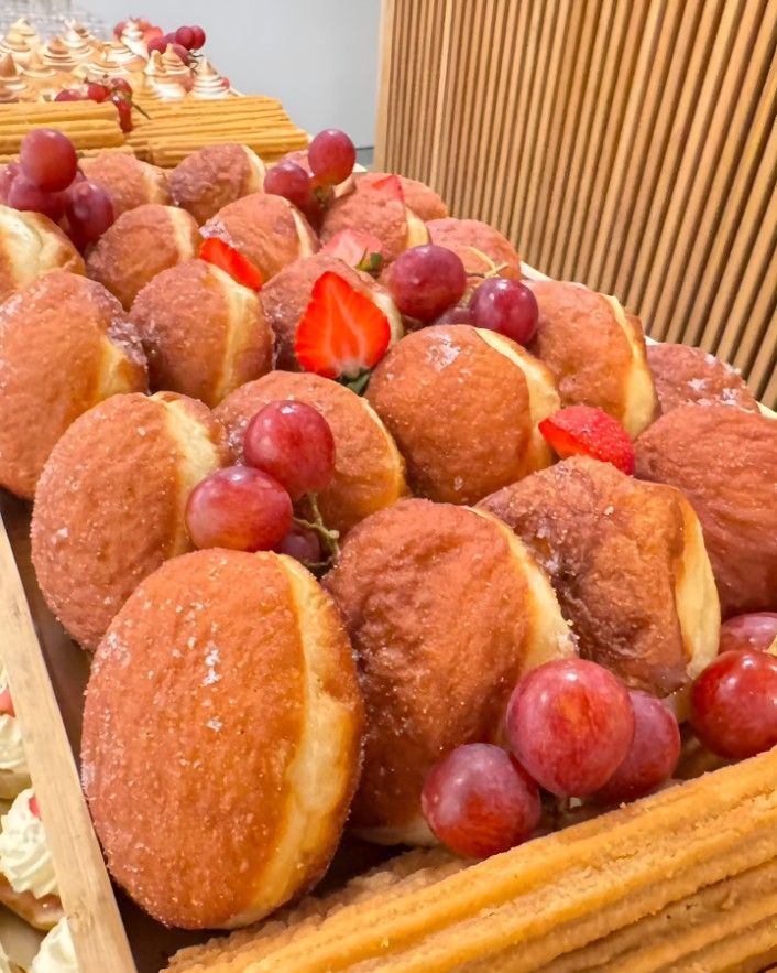 A Wooden Box Filled With Donuts, Grapes and Strawberries — Darwin Catering Company in Brinkin, NT
