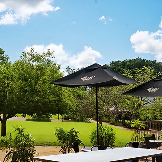 A Table With a Black Umbrella That Says Walker on It — Darwin Catering Company in Brinkin, NT