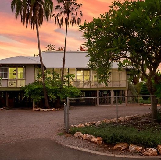 A House With a Lot of Windows and Palm Trees in Front of It — Darwin Catering Company in Brinkin, NT