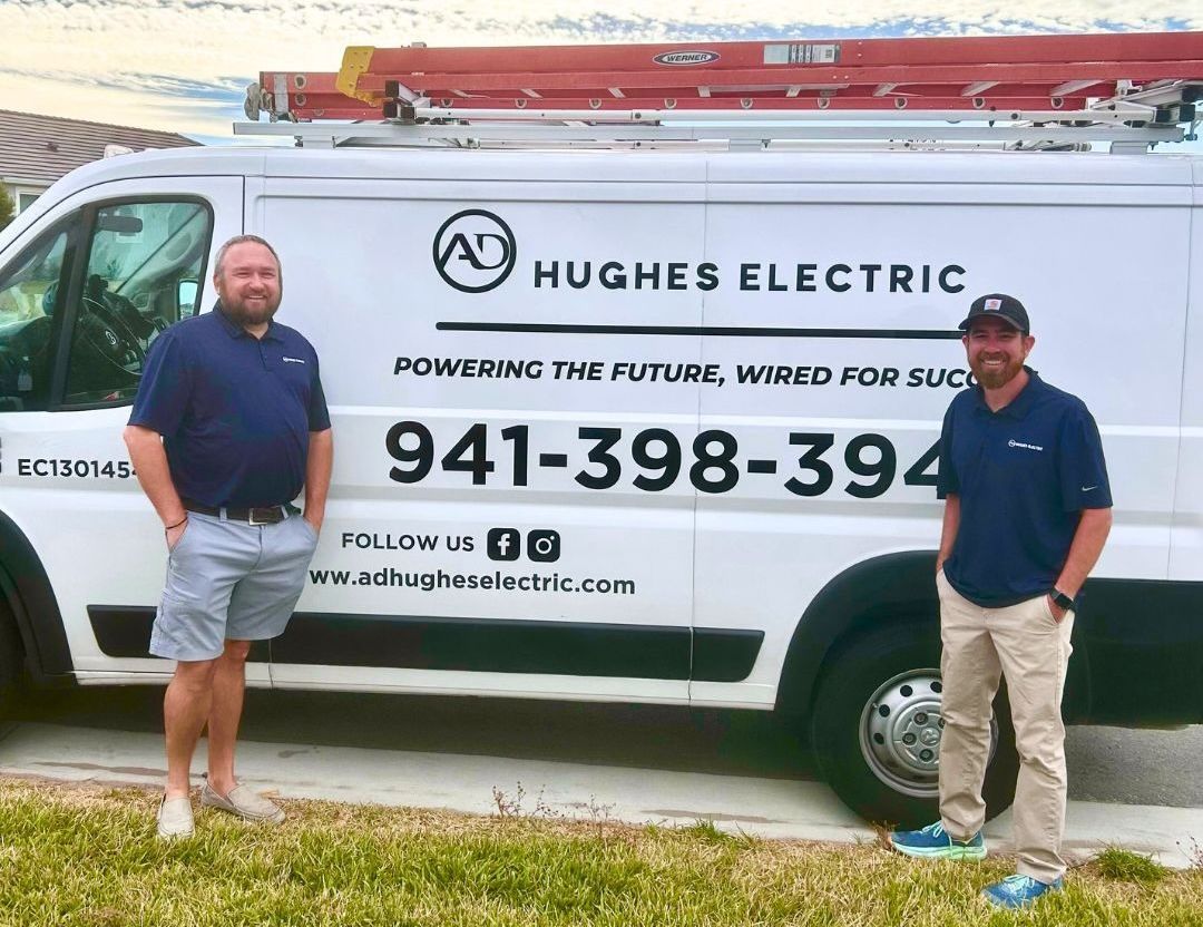 Empty, industrial warehouse interior; concrete floor reflects overhead lights, open bay door.