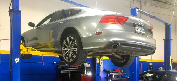 A car is sitting on a lift in a garage.