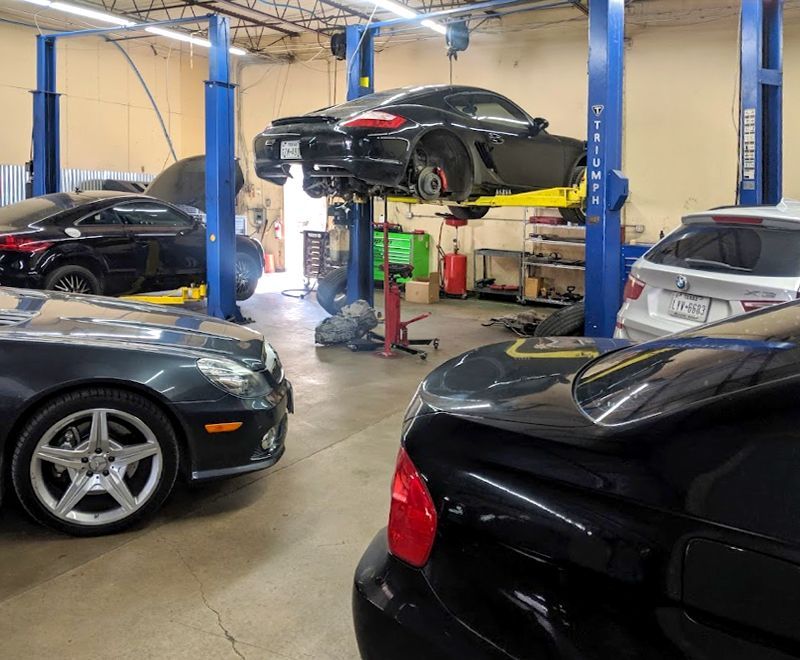 A garage with a lot of cars on lifts