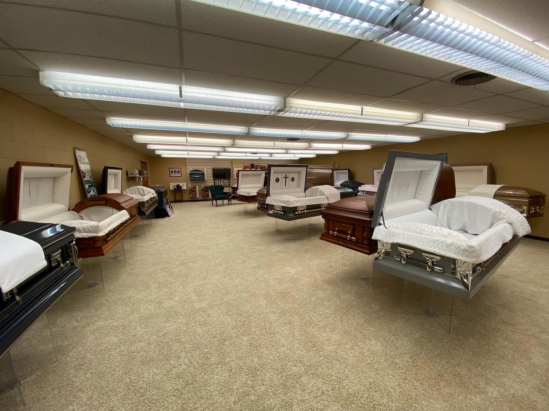 A room displaying several open caskets of various colors and styles.