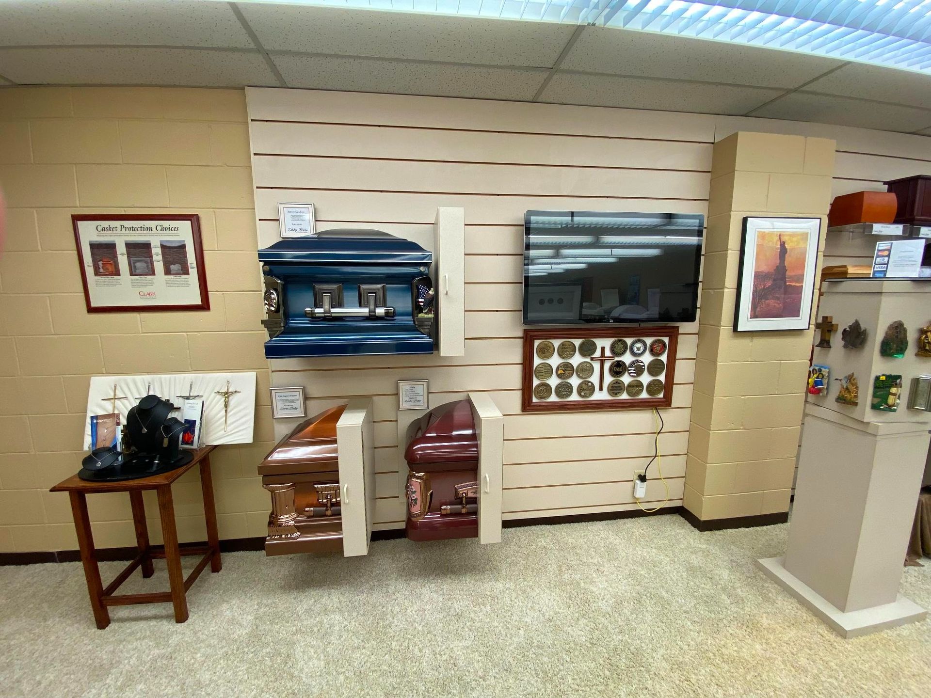 Interior of a funeral home displaying caskets, urns, and memorial items on the walls and shelves.