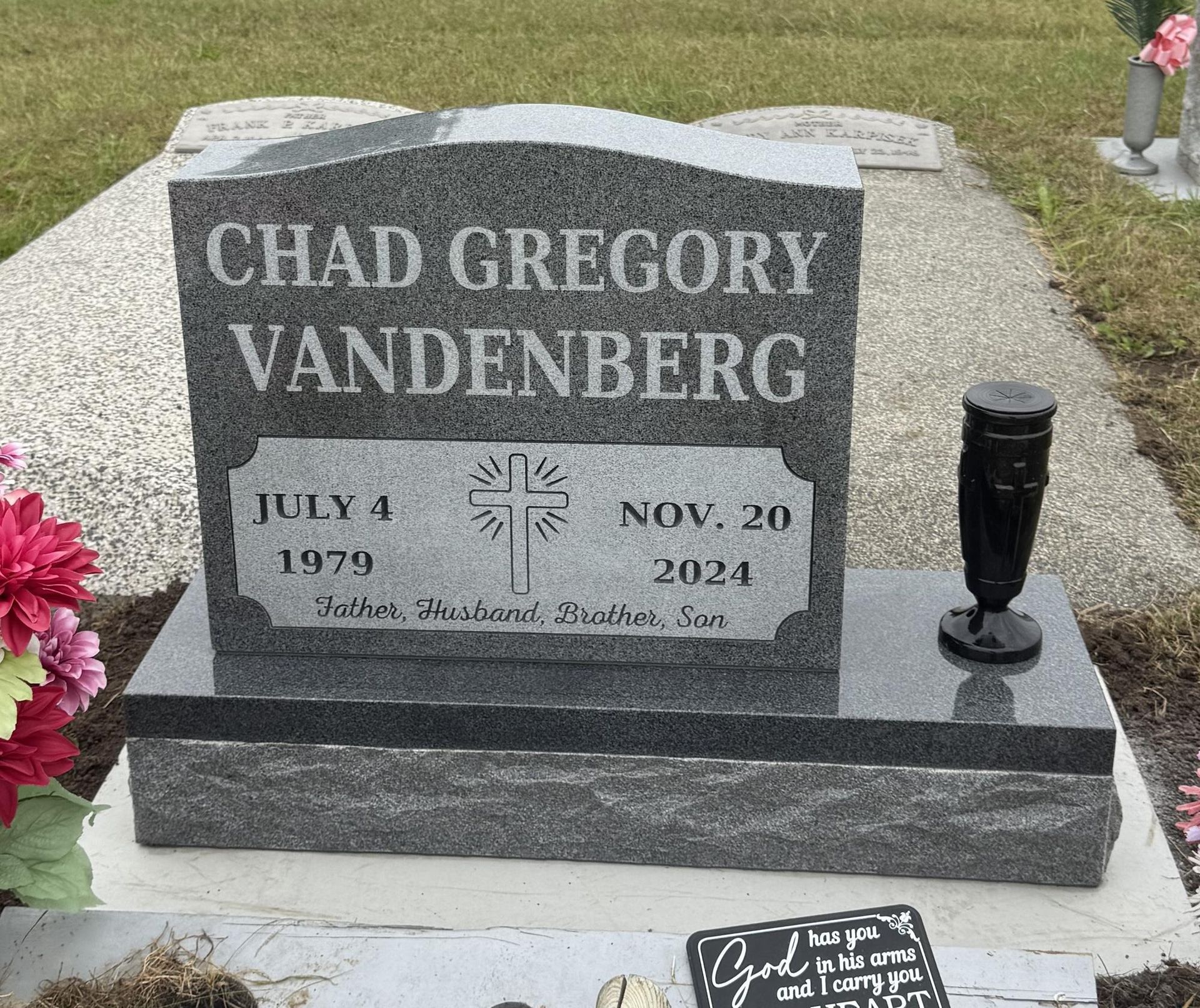 Headstone of Chad Gregory Vandenberg; dates July 4, 1979 - Nov. 20, 2024. Includes a cross and vase.
