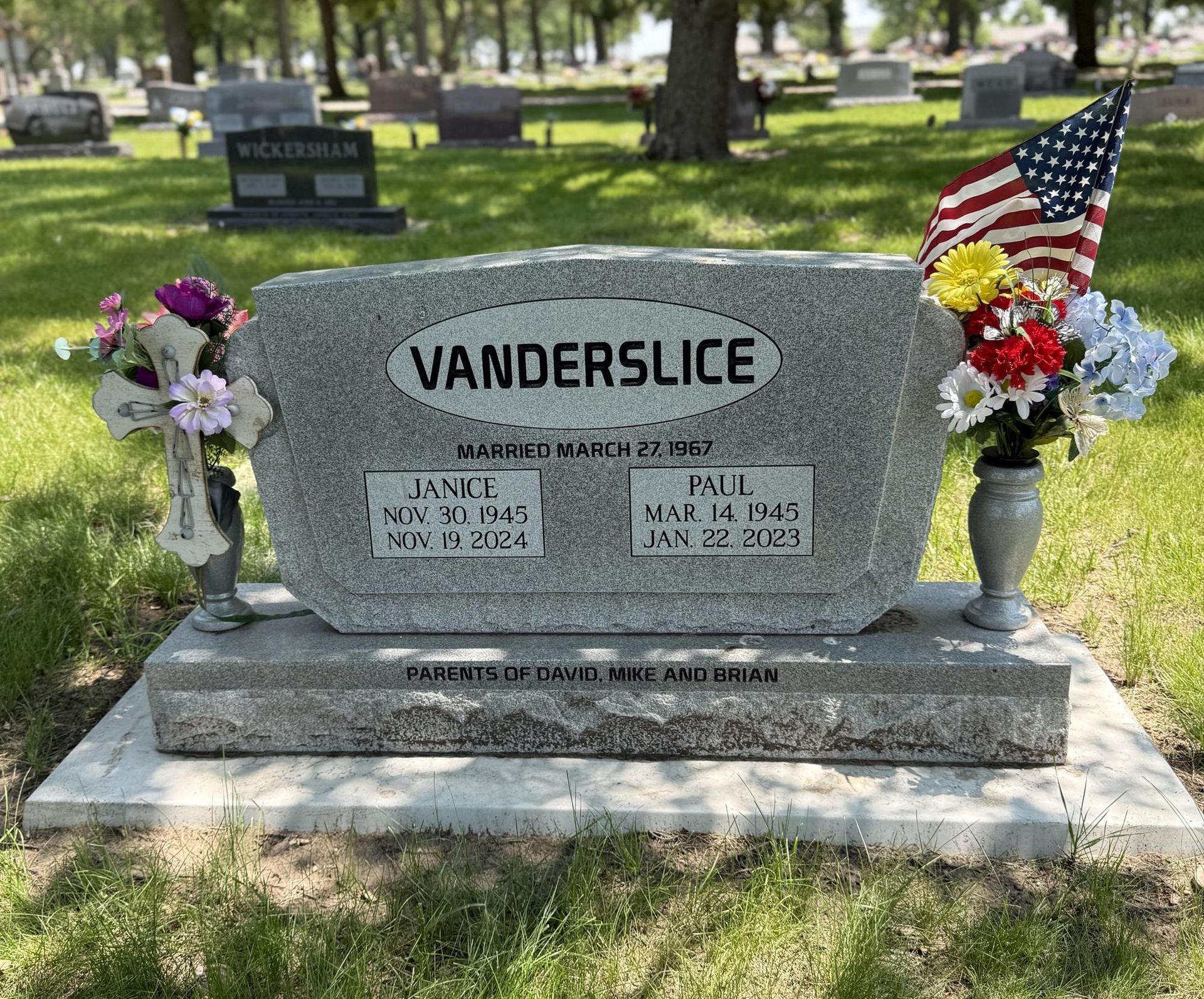 Gravestone for the Vanderslice family with American flag and flowers.