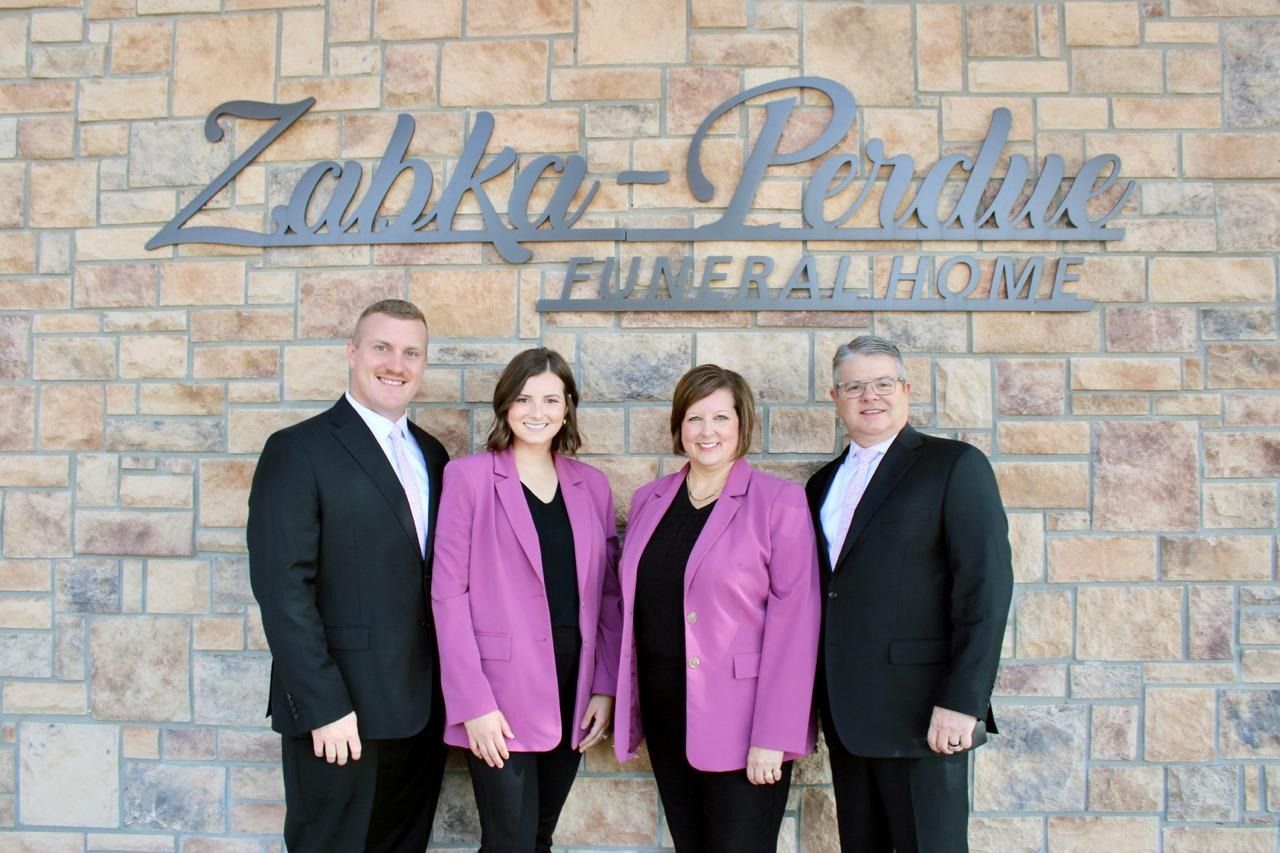 The front door of a house with a porch and plants in front of it.