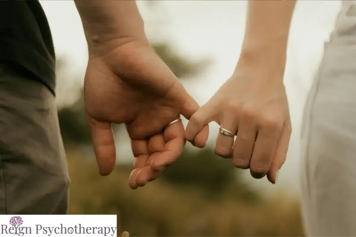 A close-up of a couple's hands with wedding rings.