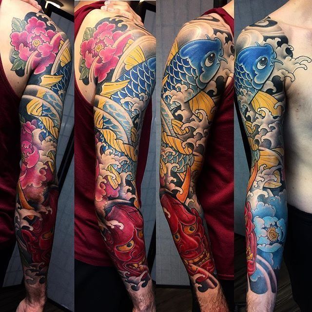 A man has a full sleeve tattoo of fish and flowers