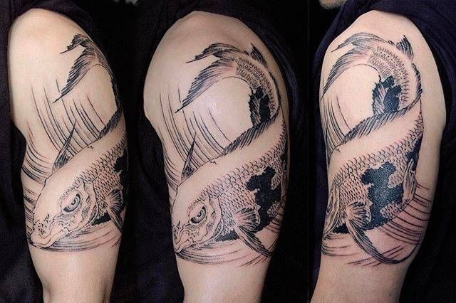 A man has a tattoo of a fish on his arm