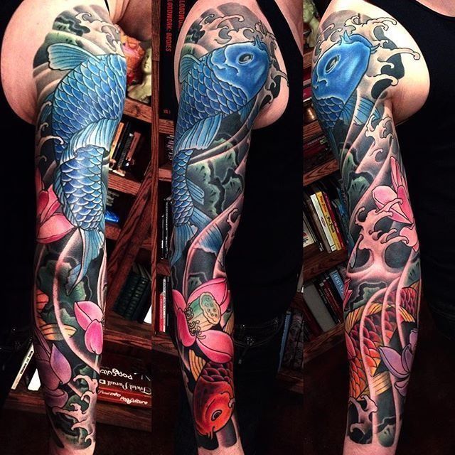 A man has a full sleeve tattoo of a fish and flowers