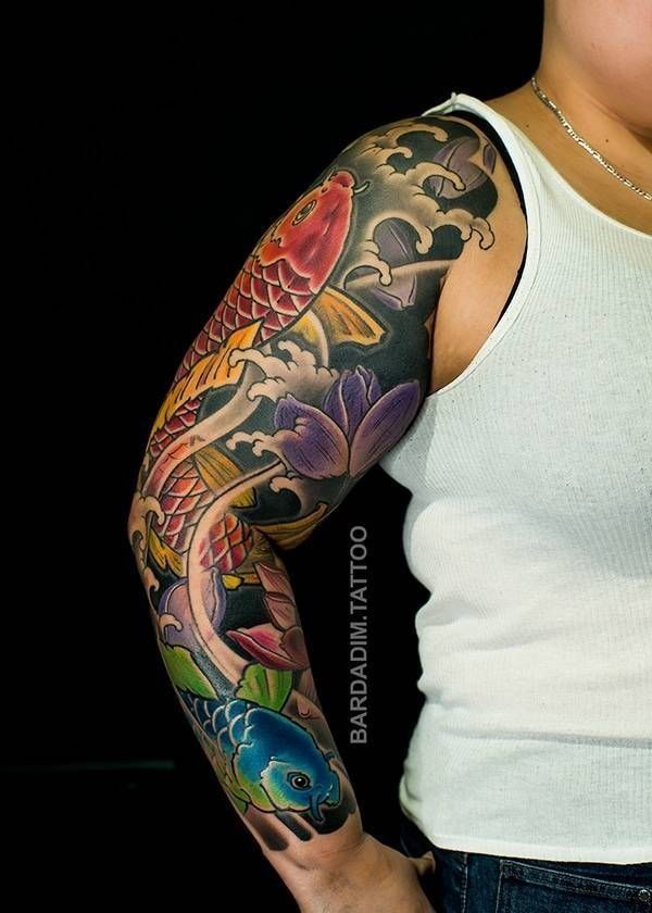 A woman has a tattoo of a fish and flowers on her arm