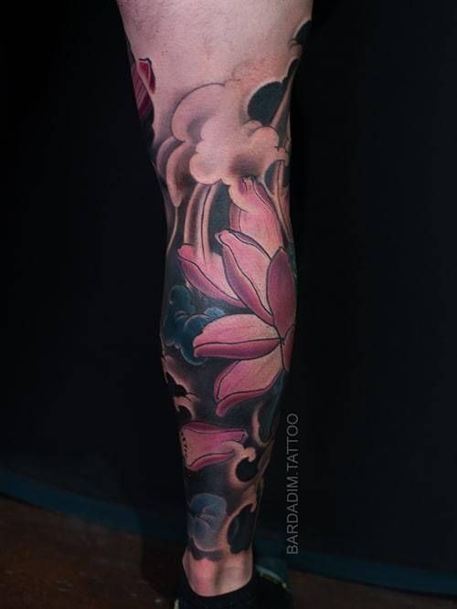 A person has a tattoo of a lotus flower on their leg.