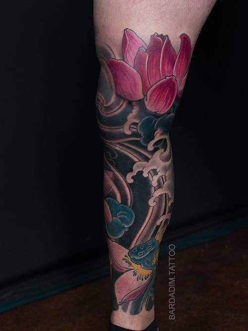 A woman has a tattoo of a lotus flower on her leg.