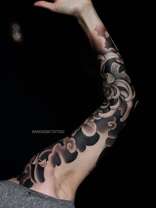 A man has a black and brown tattoo on his arm.