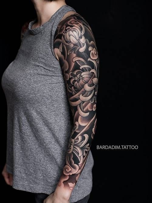 A woman has a full sleeve tattoo on her arm.