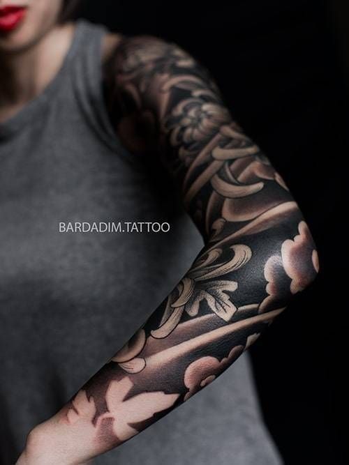 A woman has a tattoo on her arm that says barbadia tattoo